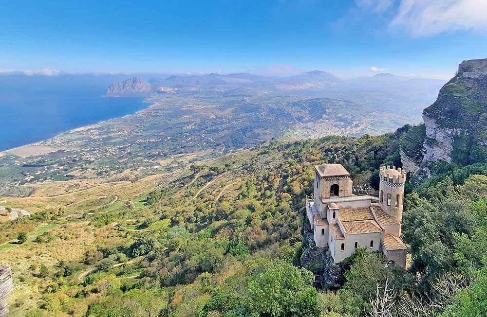 A view from Erice, with a small castle in the foreground and mountains and the sea in the background. Discover some of the best things to do in Trapani, Sicily and the most efficient way to see them in a 1, 2, 3 or 4 day Trapani itinerary. 