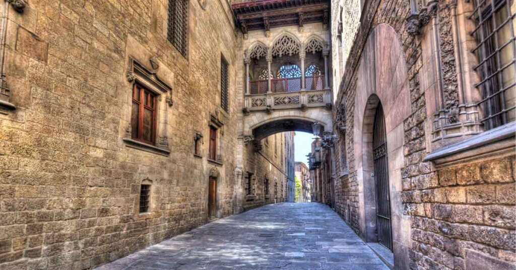 Stone-paved alley in Barcelona’s Gothic Quarter, featuring the iconic Bishop’s Bridge—showcasing the historic charm of one of the best cities to visit in Spain.