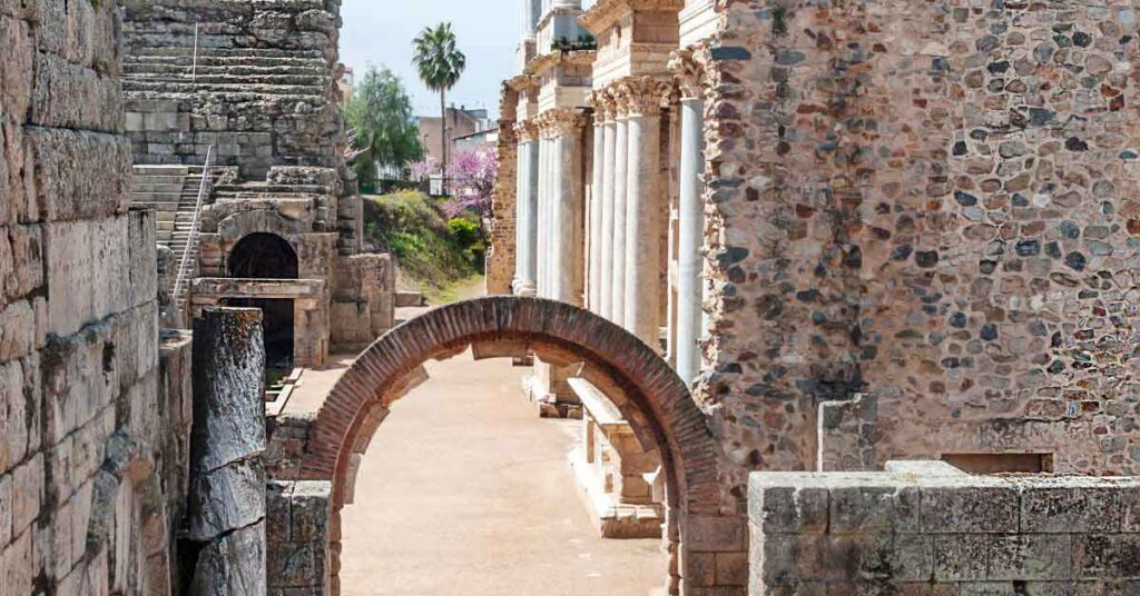 Stone arch and columns of the Roman Theatre in Mérida, Spain, part of a UNESCO World Heritage Site often listed among the Best Roman Ruins in Spain.